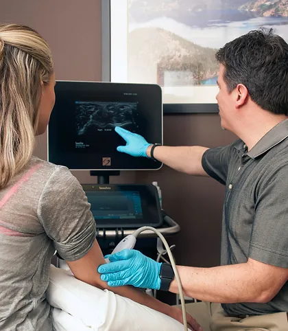 A doctor diagnosing patient with ultrasound machine